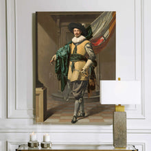 Load image into Gallery viewer, A portrait of a man dressed in historical royal clothes with a black hat hangs on a white wall above a lamp and two candles