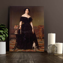 Load image into Gallery viewer, Portrait of a woman with dark hair, dressed in a royal black dress, stands on a gray wooden table with two candles