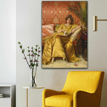 Load image into Gallery viewer, Portrait of a woman with dark hair wearing a royal yellow dress hangs on a white wall above a yellow armchair

