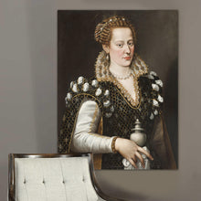 Load image into Gallery viewer, Portrait of a woman with blond hair dressed in black royal clothes hangs on a gray wall near a gray armchair