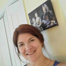 Load image into Gallery viewer, A woman stands near a portrait of herself with her family dressed in historical royal clothes