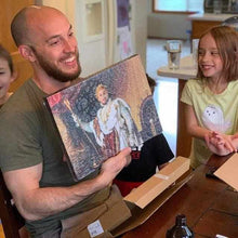 Load image into Gallery viewer, A man holds a portrait of himself, dressed in regal clothes, and the girl looks at it with a smile