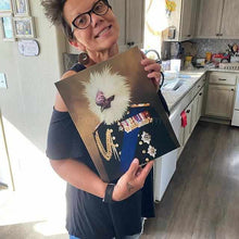 Load image into Gallery viewer, A woman in glasses and a black blouse stands in the kitchen and holds a canvas depicting a bird with the human body in a veteran attire