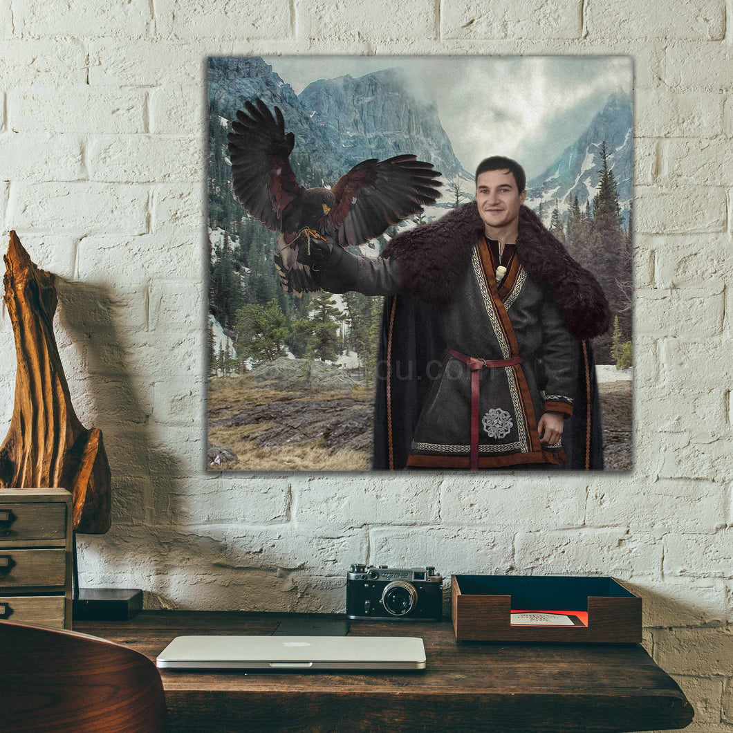 A portrait of a man dressed as a Viking holding a bird in his hand hangs on the white brick wall above his desk