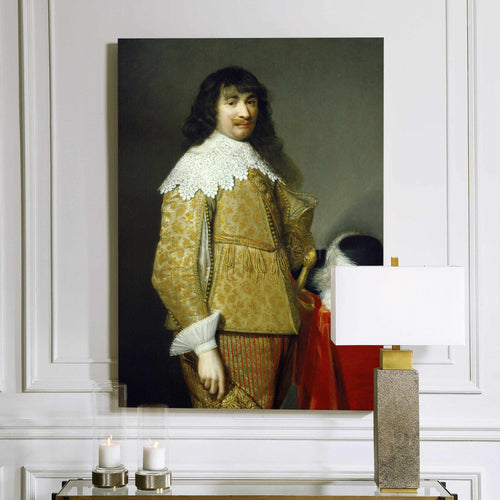 A portrait of a man with long hair dressed in yellow royal clothes hangs on a white wall