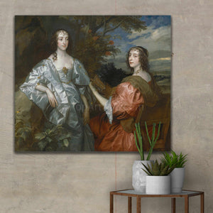 Portrait of two women dressed in royal clothes hanging on a beige wall near cacti