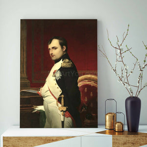 A portrait of a man standing near a red chair dressed in historical royal clothes stands on a white table next to a gray vase