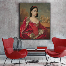 Load image into Gallery viewer, Portrait of a woman dressed in red regal attire hangs on a gray wall next to two red armchairs
