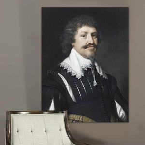 A portrait of an elderly man dressed in black royal clothes hangs on the gray wall above the chair