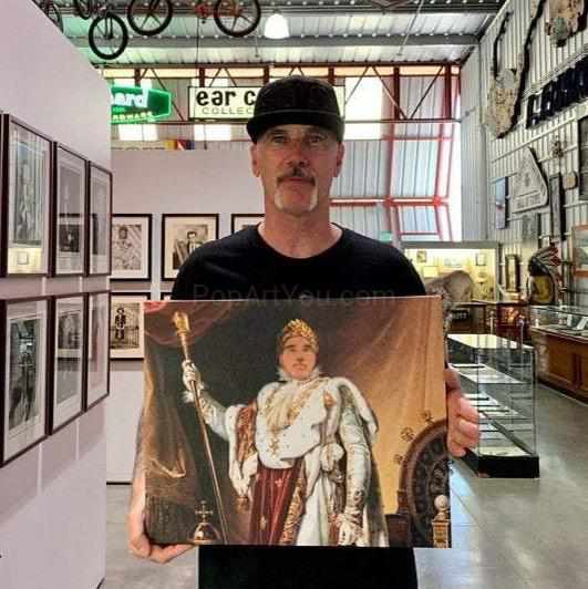 A man holding a portrait of himself dressed in regal attire