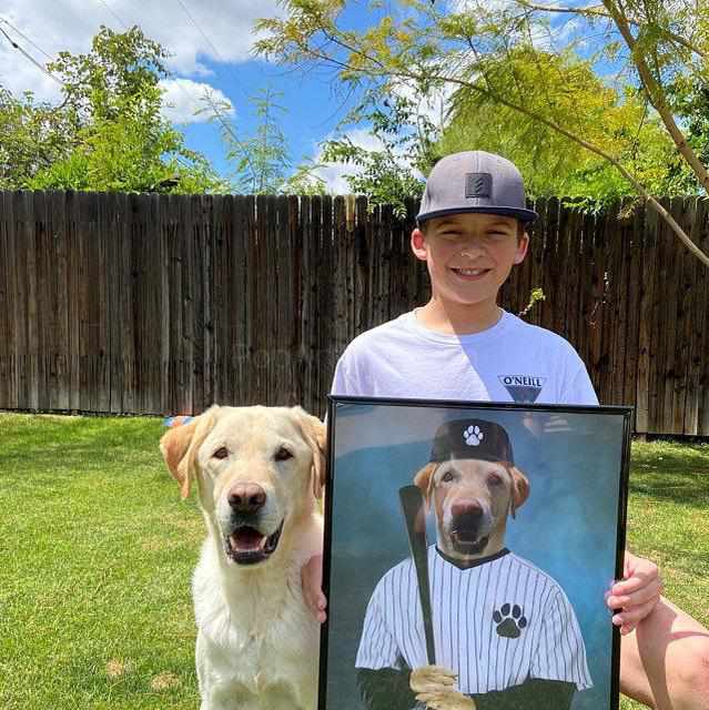 Boy with dog holding a portrait of a dog with a human body dressed in baseball clothes with a bat