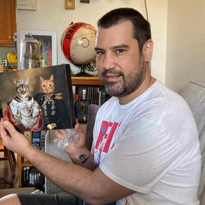 A man holds a canvas portrait of two cats, dressed in historical attires