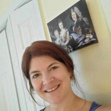 Load image into Gallery viewer, A woman stands near a portrait of herself with her family dressed in historical royal clothes
