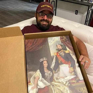A man with glasses with a smile on his face is holding a portrait of himself with his couple dressed in historical royal clothes