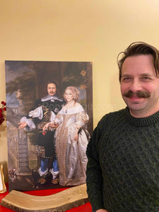 A man stands near a portrait of himself with his married couple dressed in historical regal attires