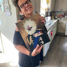 Load image into Gallery viewer, A woman in glasses and a black blouse stands in the kitchen and holds a canvas depicting a bird with the human body in a veteran attire
